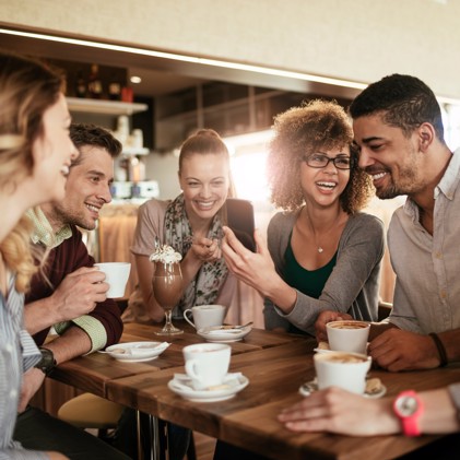 Friends enjoying a cup of coffee at a cafe.